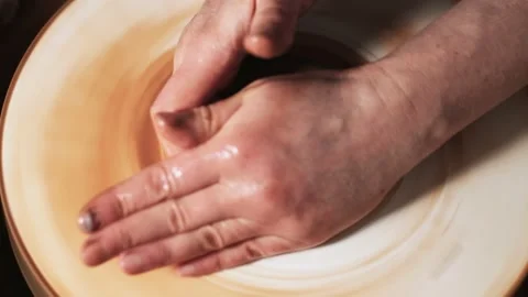 Hands working clay on potter's wheel. Potter shapes the clay product with potter Video stock 144067503