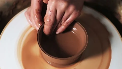 Hands working clay on potter's wheel. Potter shapes the clay product with potter Video stock 144069253