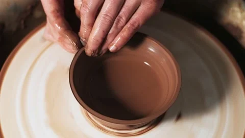 Hands working clay on potter's wheel. Potter shapes the clay product with potter Video stock 144069301