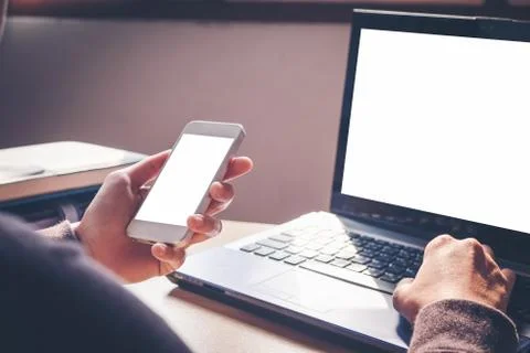 Hands working on computer typing laptop keyboard using Smart phone in busin.. Stock Photos