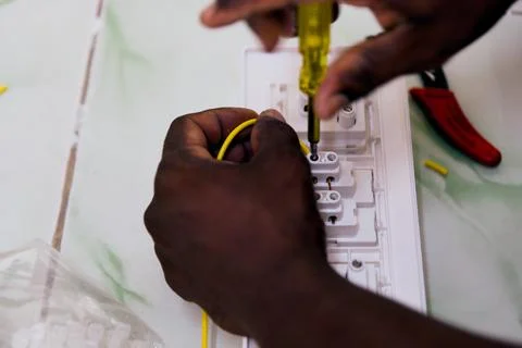 Hands working on electrical wiring with screwdriver Stock Photos