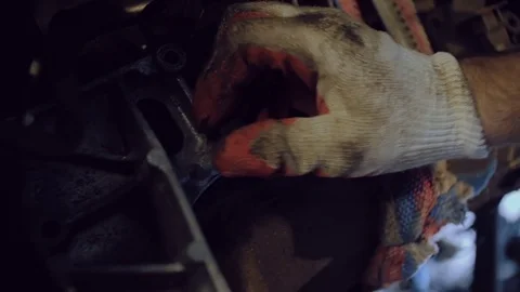 Hands in working gloves bolt the part to the motor. Stock Footage 77177766