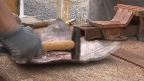 Hands of working man using a hammer to work metal in a construction site Stock Footage 117360236