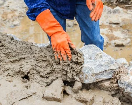 Hands working on masonry stone wall Stock Photos