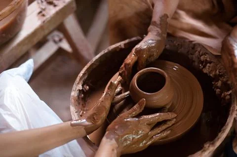 Hands working on pottery wheel. Close up of Ceramist hands at work in her Stock Photos