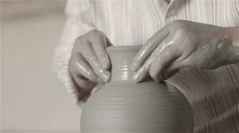 Hands working on pottery wheel, shaping a clay pot Видео 68009230
