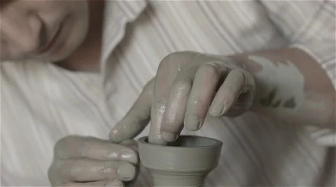 Hands working on pottery wheel, shaping a clay pot Видео 68011533