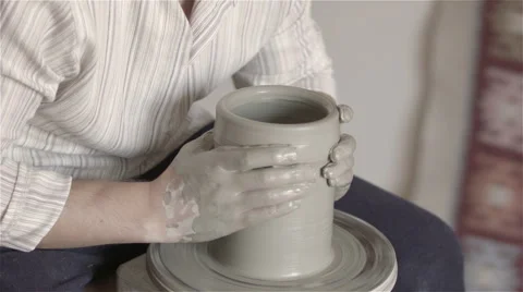 Hands working on pottery wheel, shaping a clay pot Видео 68015334