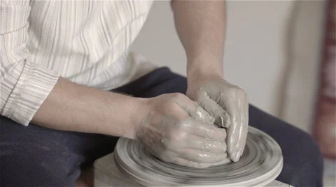 Hands working on pottery wheel, shaping a clay pot Видео 68047880