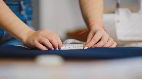 The hands working with tape measure and a textile on the table Stock Footage 107651289