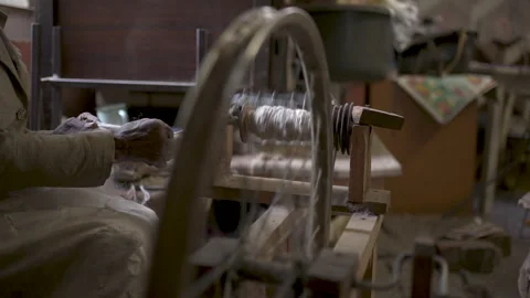 Hands Working Wool on a Spinning Wheel in a Rustic Workshop 库存影片 336211167