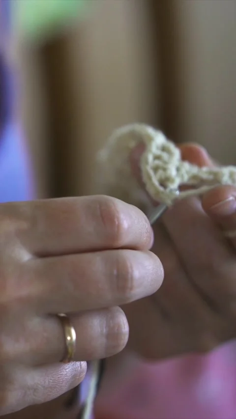 Hands working with yarn in a close-up shot showing knitting activity in a cozy i Stock Footage 328939352