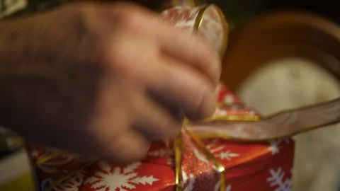 Hands Wrapping Christmas Tree red gift Box. Held closed with Ribbon. Closeup. Stock Footage 129693775