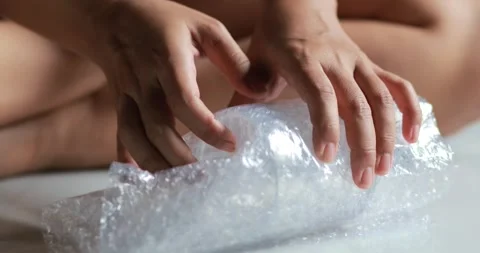 Hands wrapping a clear glass with bubble wrap for safe packaging and shippi.. Stock Footage 341768324