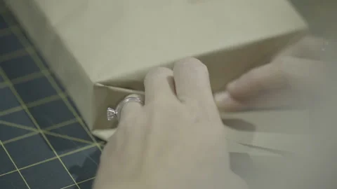 Hands wrapping invitation or present Stock Footage 160522177