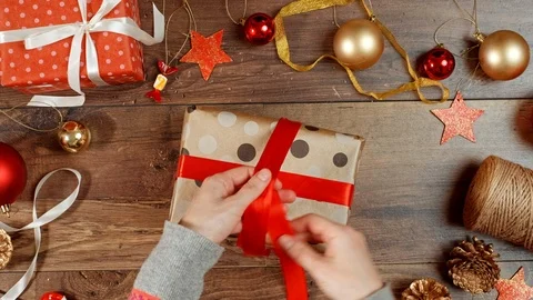 Hands wrapping present for holidays. Packaging wrapped gift box with bow. Stock Footage 117189040