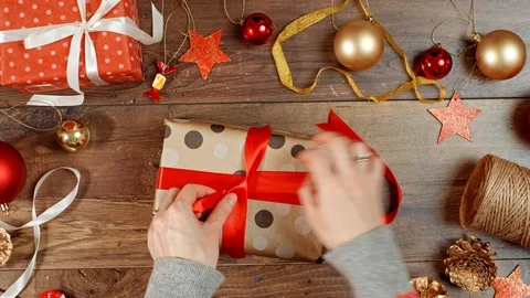 Hands wrapping present for holidays. Packaging wrapped gift box with bow. Stock Footage 117189048