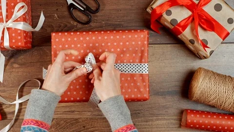 Hands wrapping present for holidays. Packaging wrapped gift box with bow. Stock Footage 117190133