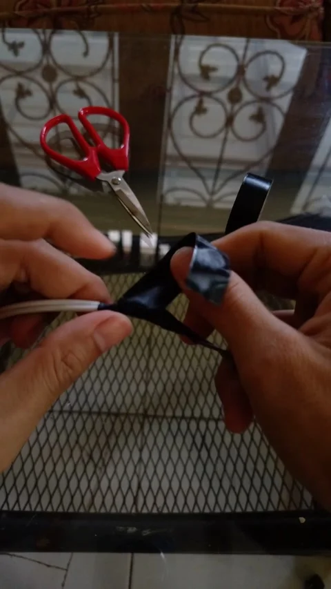 Hands wrapping smooth black electrical tape Stock Footage 332915907