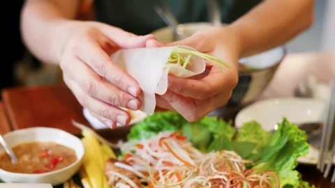 Hands Wrapping Vietnamese Spring Roll with Rice Paper and Fresh Vegetables 動画素材 332978044