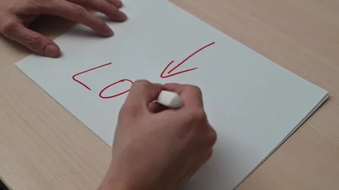 Hands write the word loss with a downward arrow on paper across four frames. 스톡 동영상 337550099