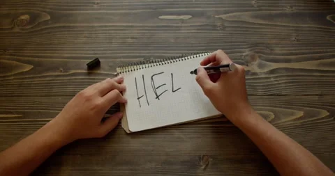 Hands writes word HELP on a paper with marker. Teenager depression Stock Footage 260937468