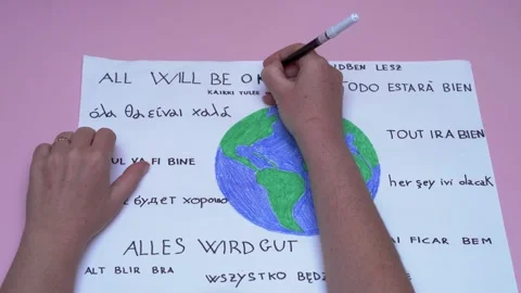 Hands writing 'all will be ok' on earth drawing Видео 277518542