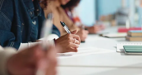 Hands, writing and students at desk with test, paper or assessment in university Stock Footage 312718305