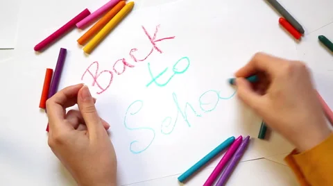 Hands writing back to school with colors on white background Stock Footage 56647947