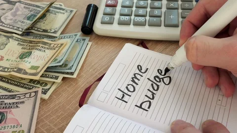 Hands writing Home budget in a note pad. Stock Footage 88346397