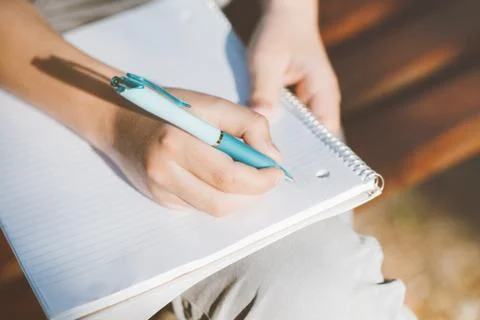 Hands writing in notebook. Stock Photos