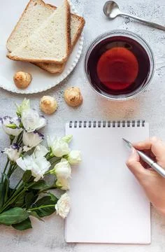 Hands writing on a notepad, breakfast setting, copy space Stock Photos