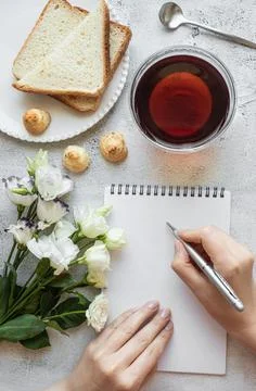 Hands writing on a notepad, breakfast setting Stock Photos