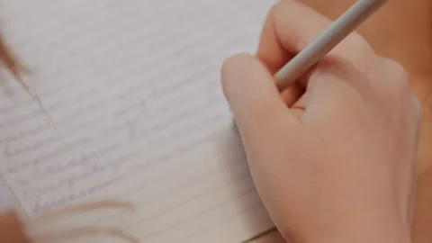 Hands writing notes. Closeup of hands jotting down thoughts in notebook. Warmly Stock Footage 335887209