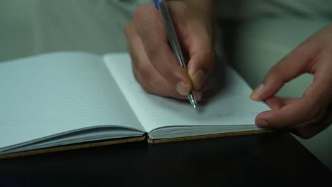 Hands Writing Notes in Notebook During Podcast Planning Session Stock Footage 337155730