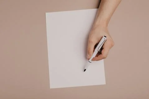 Hands writing on paper blank a4 size on grey background. Stock Photos