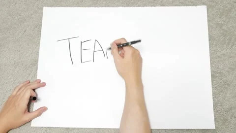 Hands writing teamwork on white paper Stock Footage 252251199