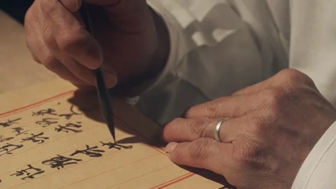 Hands Writing Traditional Calligraphy on Aged Paper with Brush 库存影片 334645907