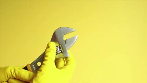 Hands in yellow rubber gloves with adjustable wrench close up Stock Footage 147537553