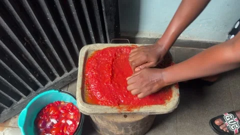 The Hands of a Young African Woman Grinding Fresh Toamtoes with a Hand Mill to 動画素材 346637341
