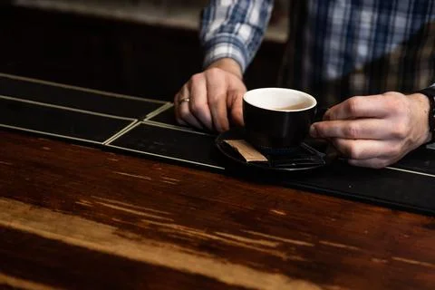 Hands of young bartender in uniform making espresso coffee on coffee machin.. Stock Photos
