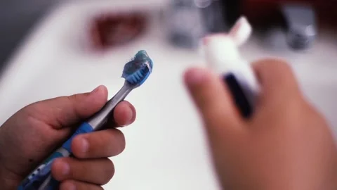 Hands of a Young Boy Putting Toothpaste on Brush in Bathroom. Close Up. Stock Footage 104641221