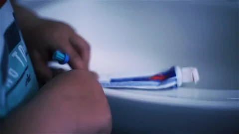 Hands of a Young Boy Squeezing an Empty Toothpaste Tube. Stock Footage 87322554