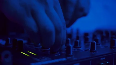 Hands of young Caucasian man touching buttons on DJ booth. Guy mixing music in Stock Footage 95928801