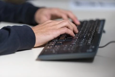 Hands of a young computer sicience student on a computer keyboard. Stock Photos