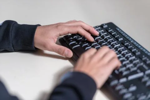 Hands of a young computer sicience student on a computer keyboard. Stock Photos