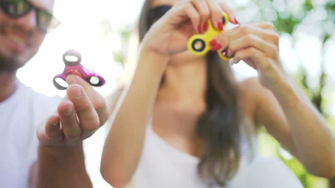 Hands of young couple while turning a hand spinner. Stock Footage 87911195