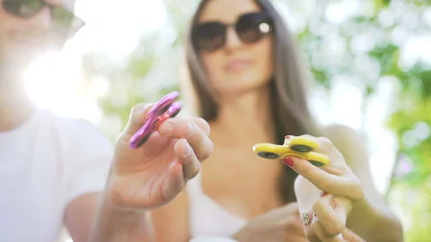 Hands of young couple while turning a hand spinner. Stock Footage 87911214