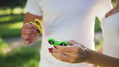 Hands of young couple while turning a hand spinner. Stock Footage 87911249