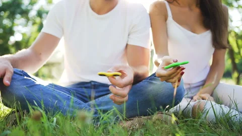Hands of young couple while turning a hand spinner. Stock Footage 87911290